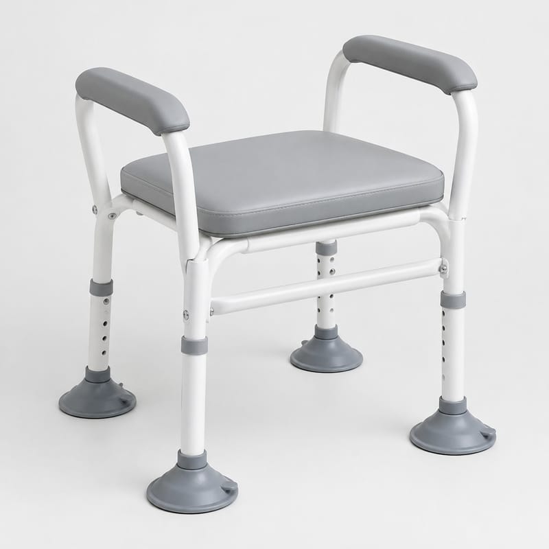 A white elevated commode seat frame with two padded grey armrests and a cushioned seat